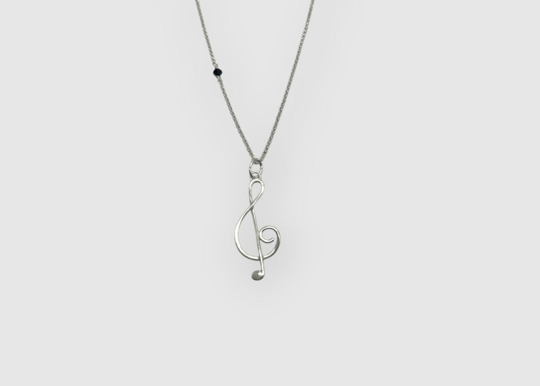 Treble clef necklace in silver on white background