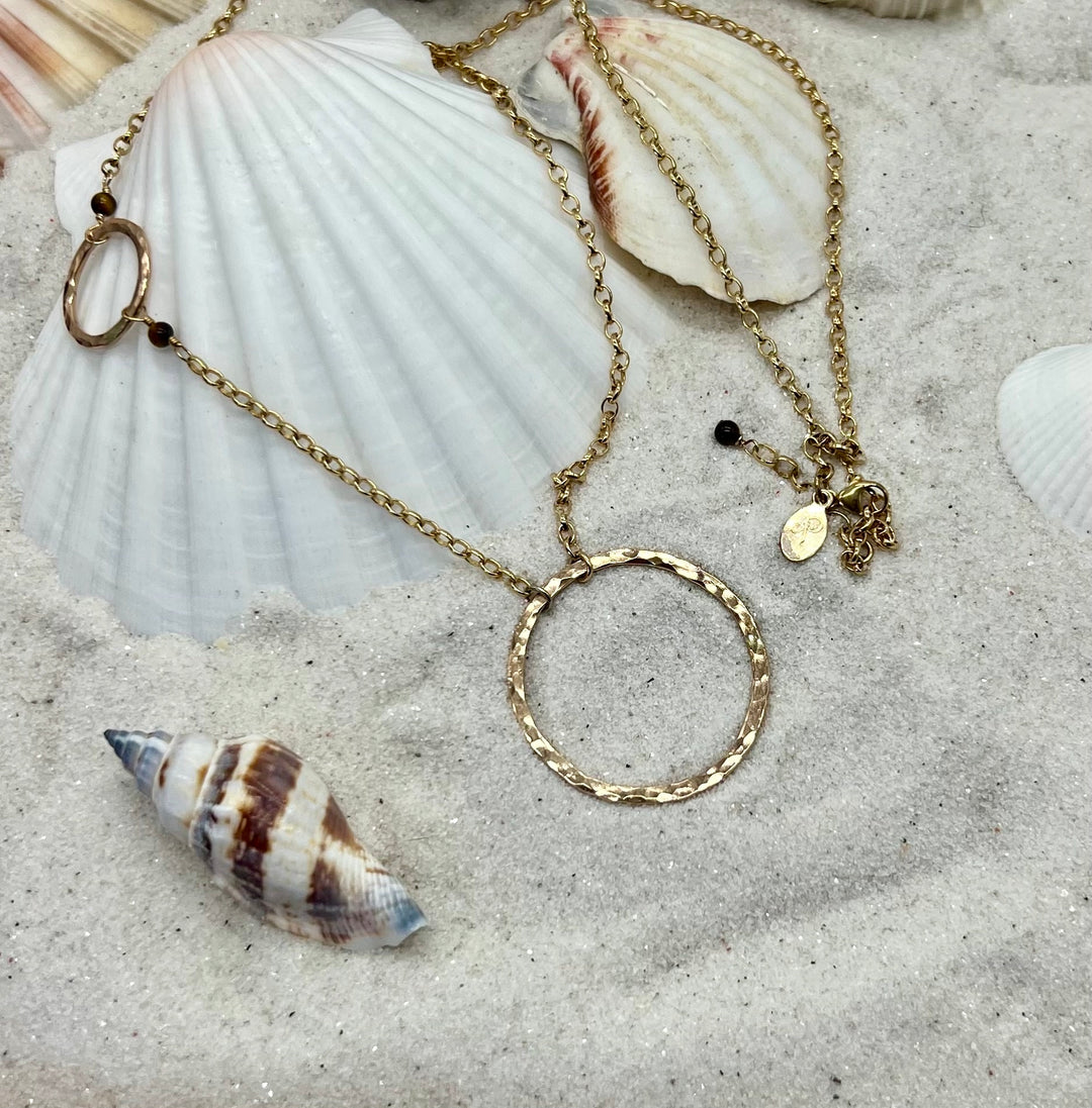 Circle necklace gold in sand and seashells