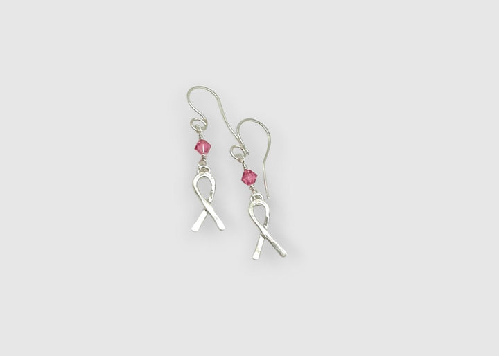 breast cancer ribbon earring on white background