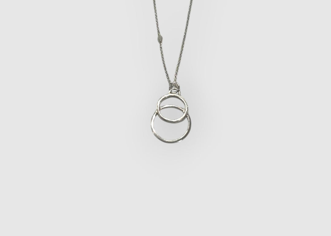 Double circle sterling silver necklace on a white background