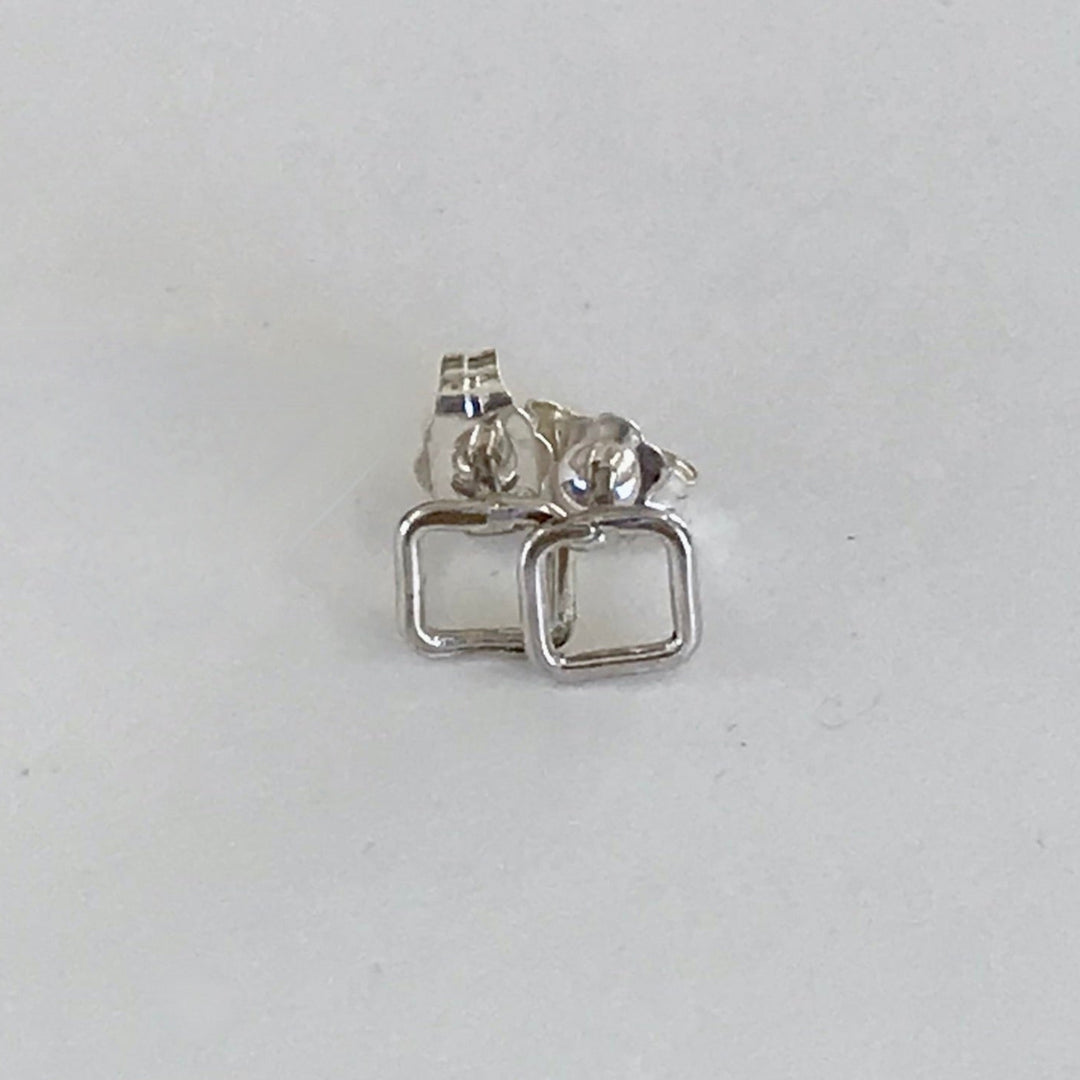 Small open square post earrings in silver on a white background