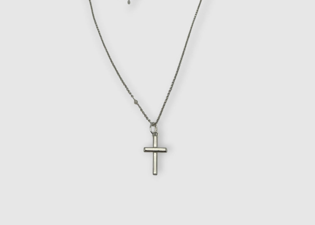 Silver cross necklace on a white background