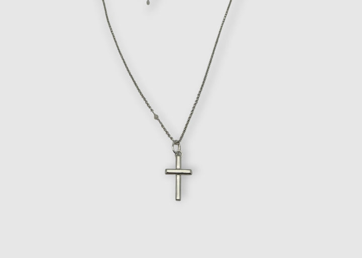 Silver cross necklace on a white background