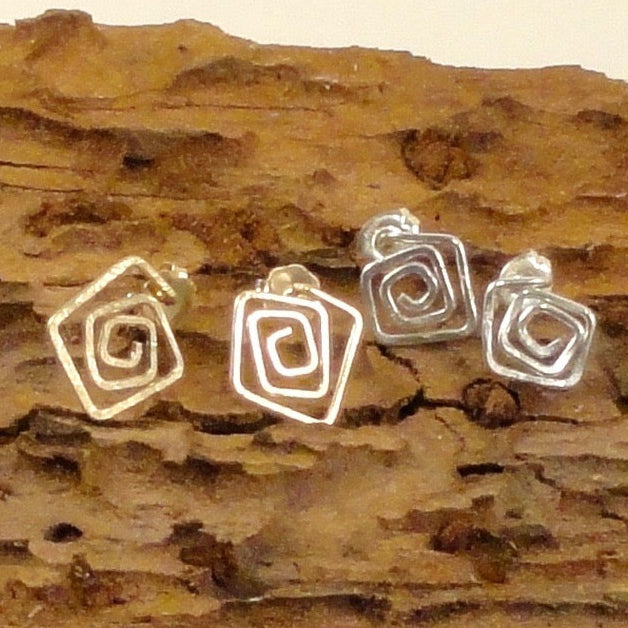 two sets of square post earrings on a log assorted color metal