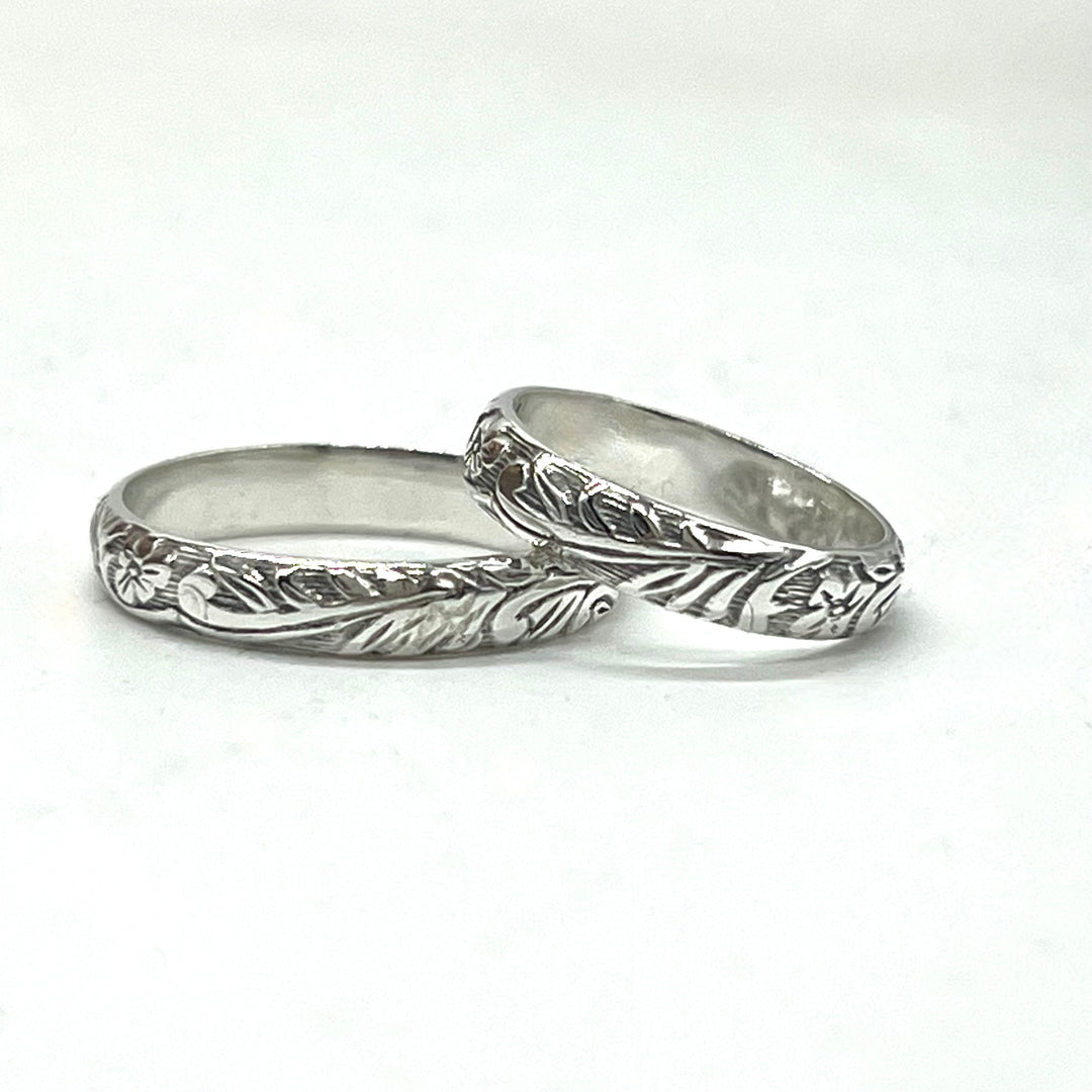 Two silver rings with intricate designs on a white background