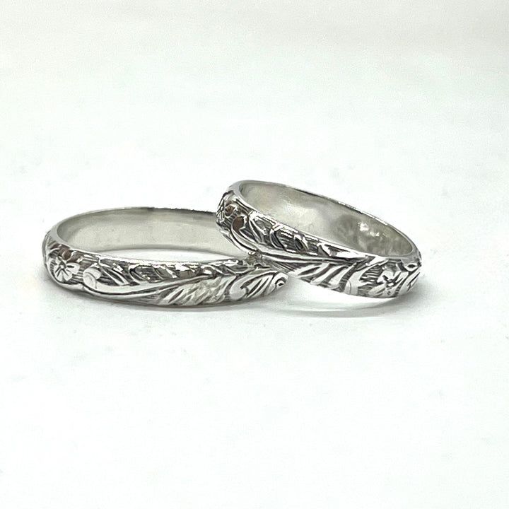 Two silver rings with intricate designs on a white background